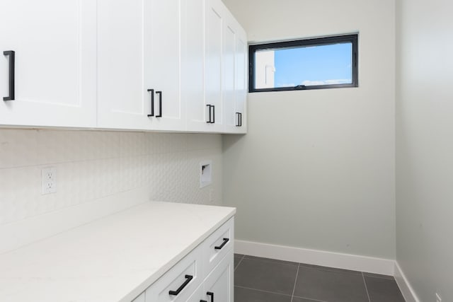 clothes washing area featuring washer hookup, dark tile patterned floors, and cabinets