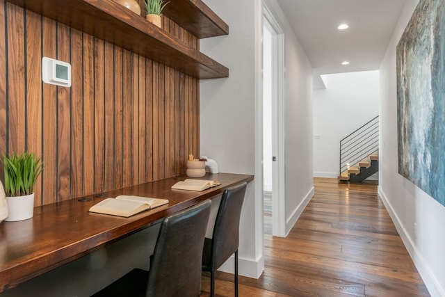 office space with built in desk and dark wood-type flooring