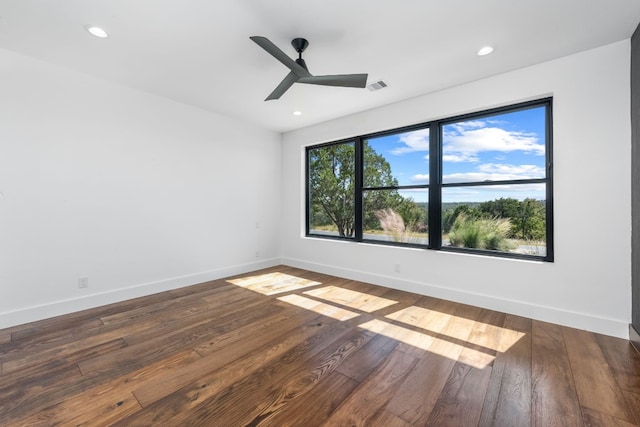 spare room featuring dark wood-type flooring and ceiling fan