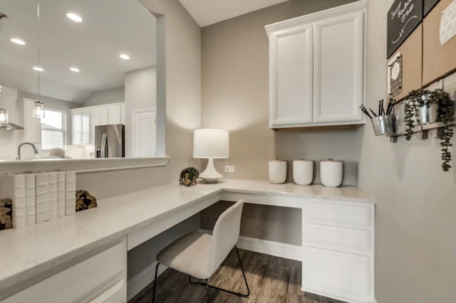 office with built in desk and dark hardwood / wood-style flooring