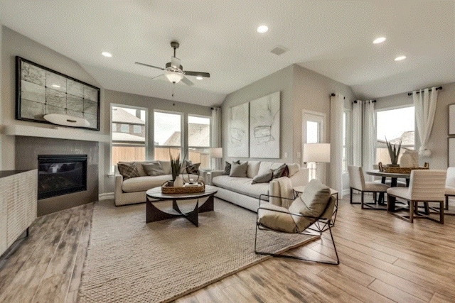 living room featuring a healthy amount of sunlight, ceiling fan, and wood-type flooring