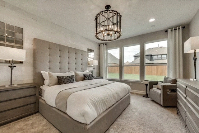 bedroom featuring light colored carpet and a chandelier