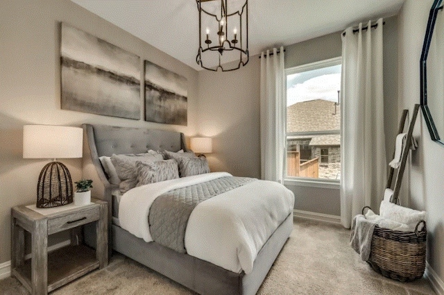 carpeted bedroom featuring a notable chandelier and a textured ceiling