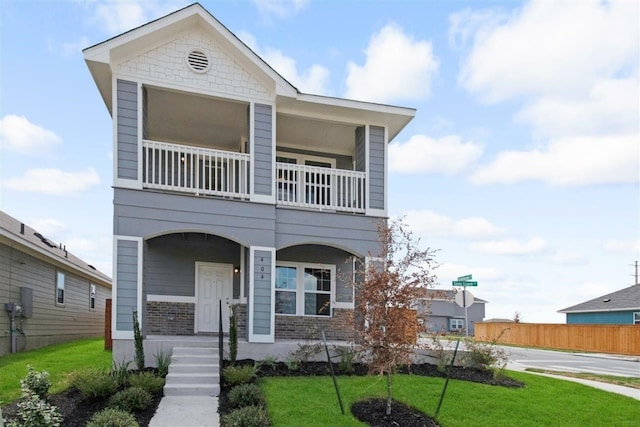 view of front facade featuring a balcony and a front yard