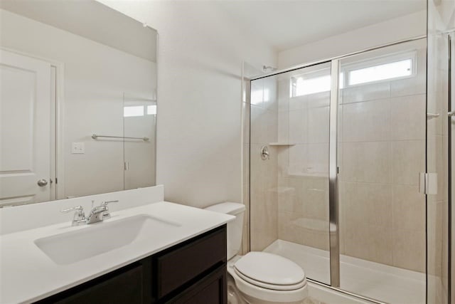 bathroom featuring vanity, toilet, and an enclosed shower