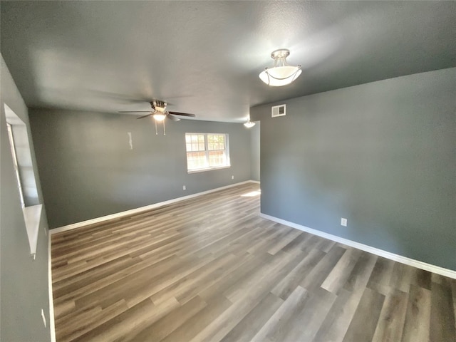 spare room featuring wood-type flooring and ceiling fan