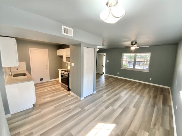 kitchen with ceiling fan, stainless steel range with electric cooktop, light hardwood / wood-style flooring, and white cabinetry