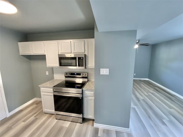 kitchen featuring light stone counters, light hardwood / wood-style floors, white cabinetry, and stainless steel appliances