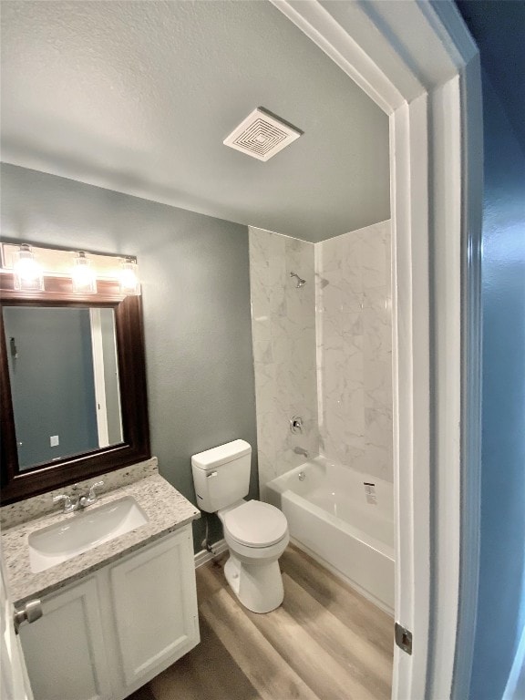 full bathroom featuring vanity, toilet, wood-type flooring, and tiled shower / bath combo