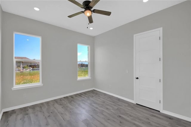 unfurnished room featuring wood finished floors, a ceiling fan, and baseboards