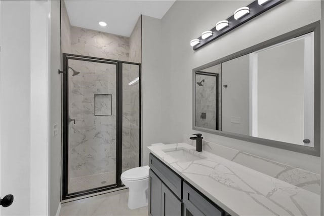 bathroom with a shower with shower door, vanity, and toilet