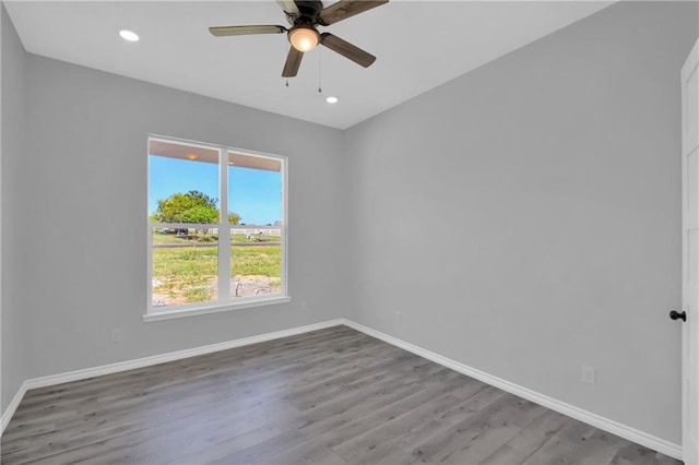 empty room featuring recessed lighting, ceiling fan, wood finished floors, and baseboards