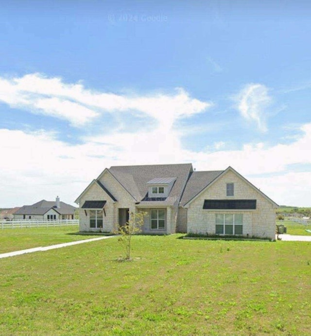 view of front of home with fence, a front yard, and stone siding