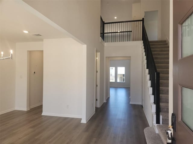 foyer entrance with stairway, baseboards, and wood finished floors