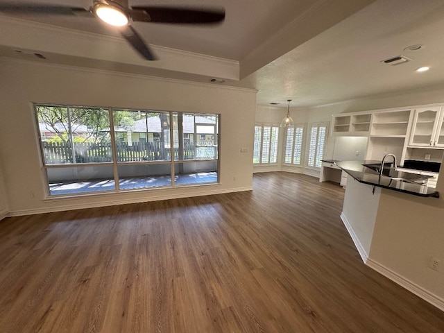 unfurnished living room featuring sink, crown molding, dark hardwood / wood-style flooring, and ceiling fan