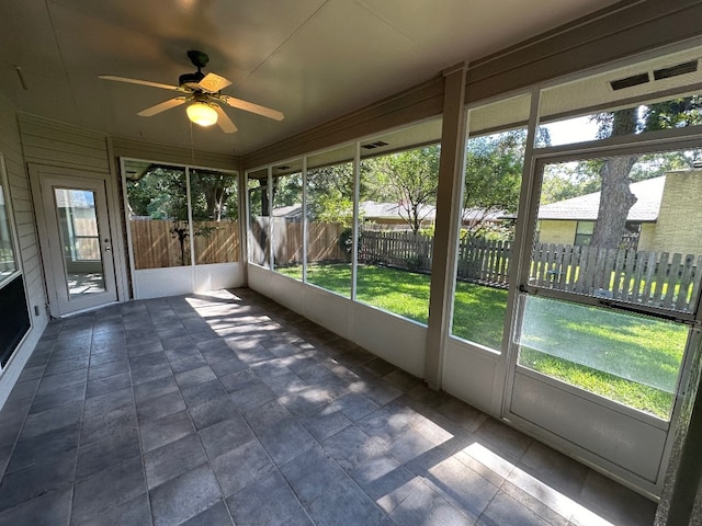 unfurnished sunroom featuring a wealth of natural light and ceiling fan