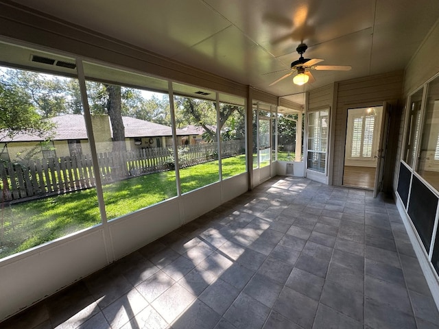 unfurnished sunroom featuring ceiling fan