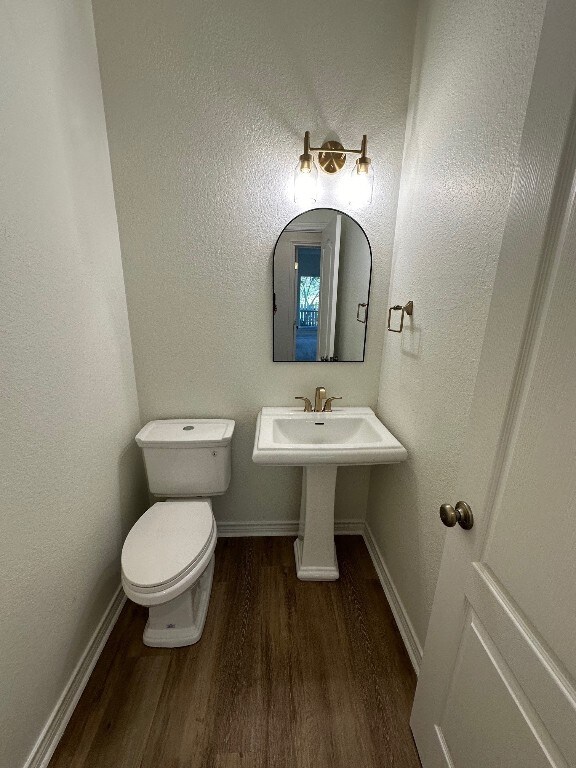 307 Stewart St, Meadowlakes, TX 78654 - half bath featuring wood finished floors, toilet, and baseboards