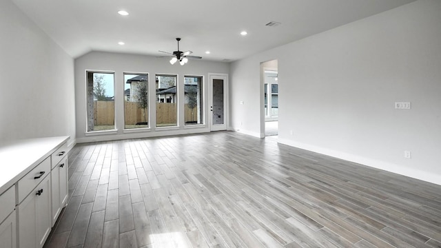 unfurnished living room with recessed lighting, visible vents, ceiling fan, wood finished floors, and baseboards