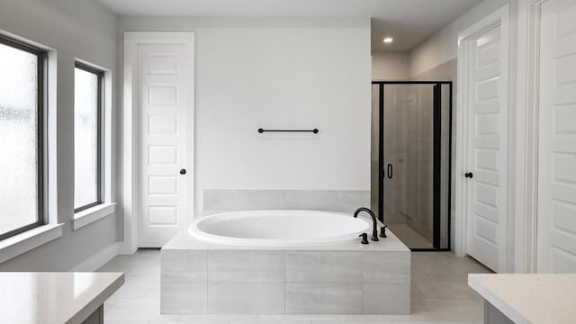 bathroom with a stall shower, a garden tub, vanity, and tile patterned floors