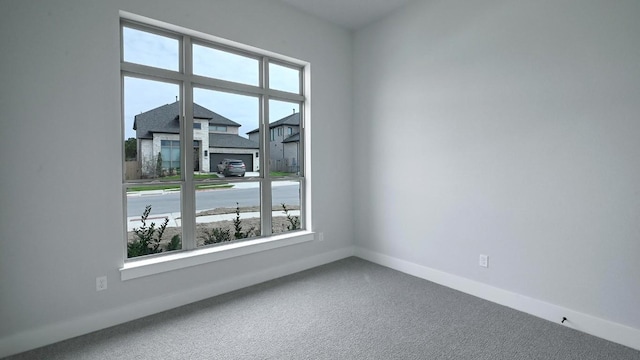 carpeted spare room with baseboards