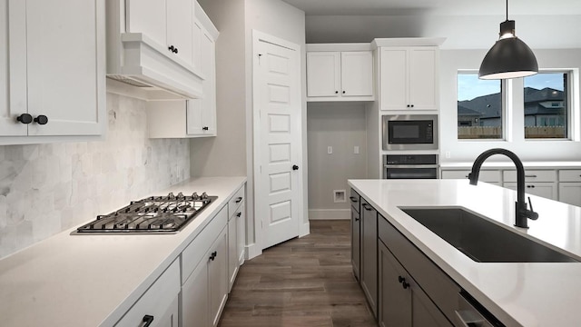 kitchen with white cabinets, appliances with stainless steel finishes, light countertops, and a sink