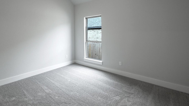 carpeted empty room featuring baseboards