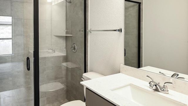 bathroom featuring toilet, a shower stall, and vanity