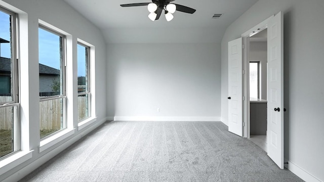 empty room featuring baseboards, carpet floors, visible vents, and a healthy amount of sunlight