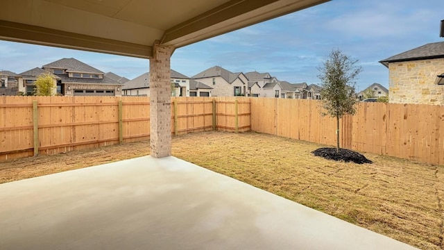 view of yard with a patio, a fenced backyard, and a residential view