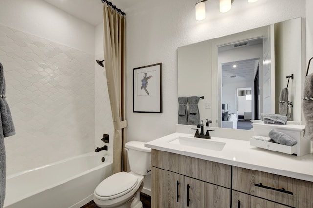 full bathroom featuring shower / bath combo, vanity, and toilet