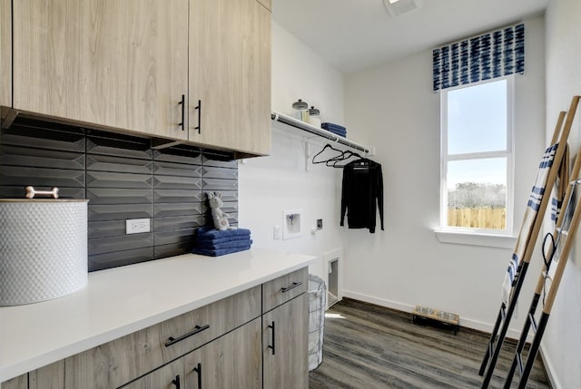 clothes washing area featuring washer hookup, cabinets, dark hardwood / wood-style flooring, and hookup for an electric dryer