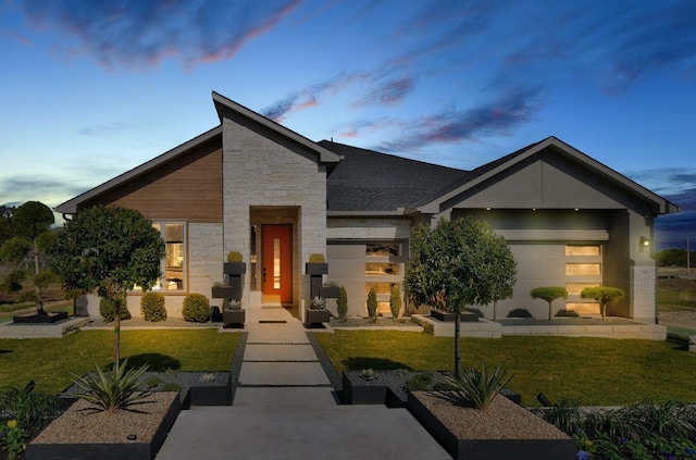 modern home featuring a garage and a yard