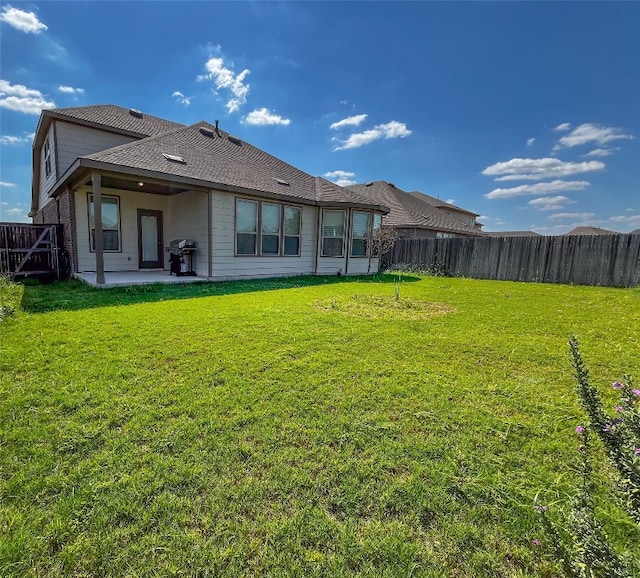 back of property with a lawn and a patio area