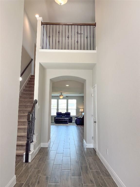 6008 Genova Pl, Round Rock, TX 78665 - entryway with a ceiling fan, stairs, arched walkways, wood finish floors, and a high ceiling