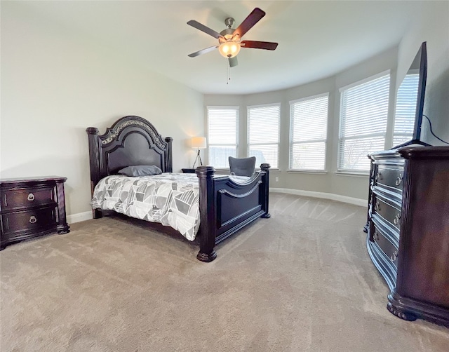 bedroom featuring ceiling fan, light colored carpet, and multiple windows