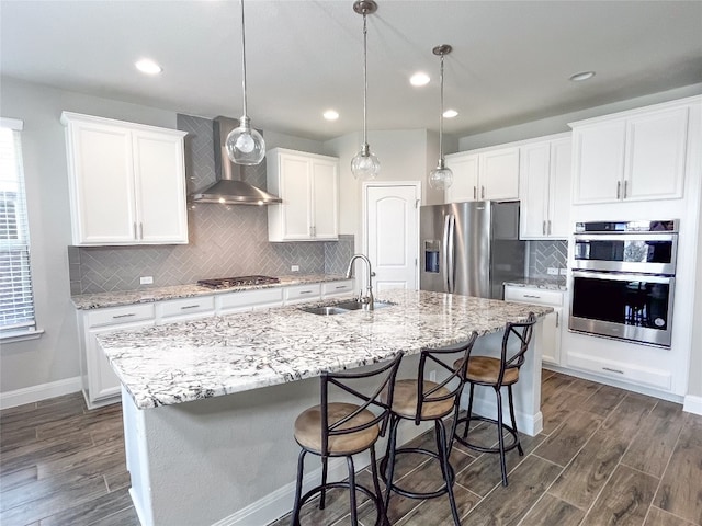 kitchen featuring a kitchen island with sink, white cabinetry, sink, and stainless steel appliances