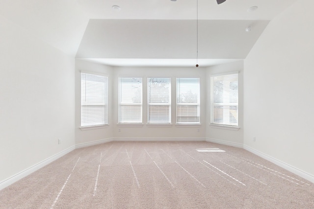 empty room featuring ceiling fan, light colored carpet, and vaulted ceiling