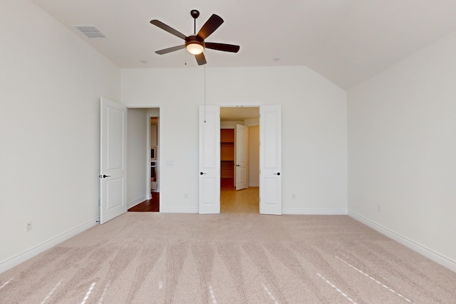 unfurnished bedroom featuring ceiling fan, light carpet, and vaulted ceiling