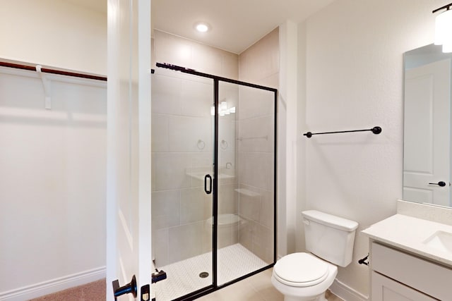 bathroom featuring vanity, toilet, and a shower with door