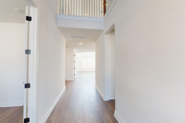 hallway featuring dark hardwood / wood-style floors and a high ceiling