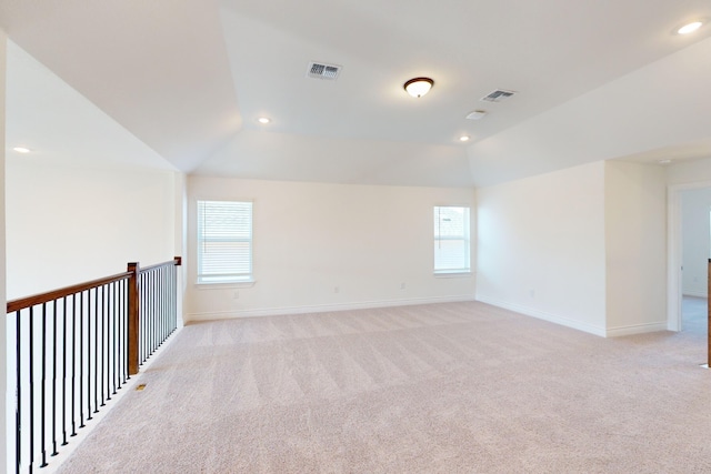 carpeted empty room with vaulted ceiling