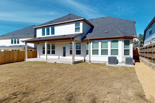 back of property with a lawn, a patio area, and central AC