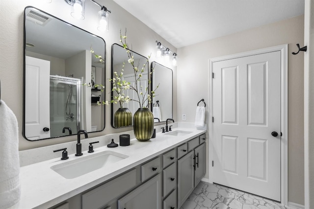 bathroom featuring a shower with door and vanity