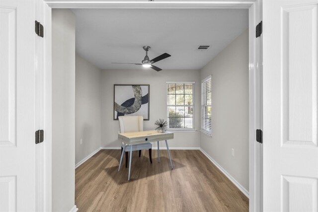 home office featuring light wood-type flooring and ceiling fan