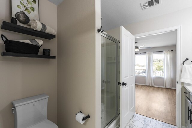 bathroom with ceiling fan, toilet, a shower with door, hardwood / wood-style flooring, and vanity