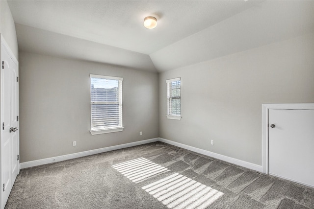 unfurnished room featuring carpet flooring and lofted ceiling