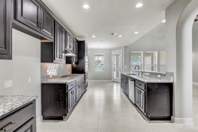 kitchen with light stone counters, sink, light tile patterned floors, and appliances with stainless steel finishes