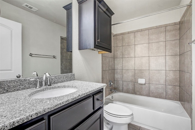 full bathroom featuring tile patterned floors, vanity, tiled shower / bath combo, and toilet