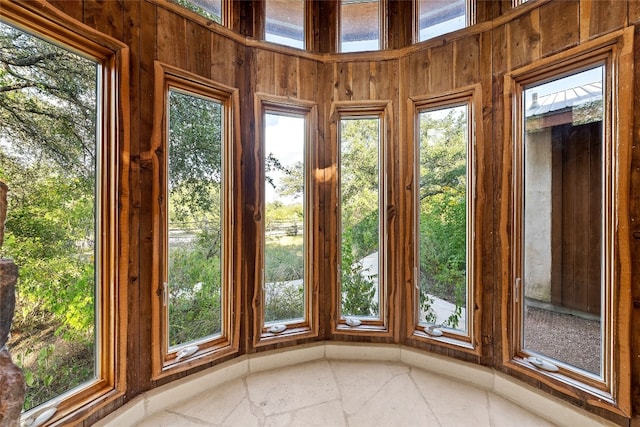 entryway with wood walls and a wealth of natural light